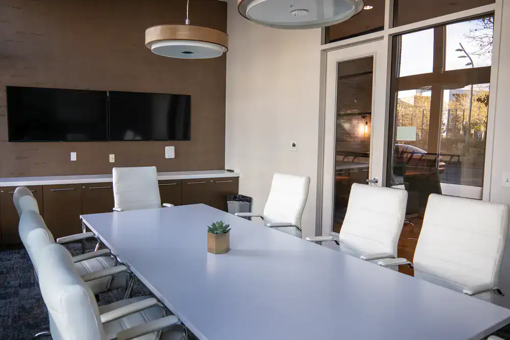 Sleek corporate boardroom with a large statement tree in the corner and small succulents on the table