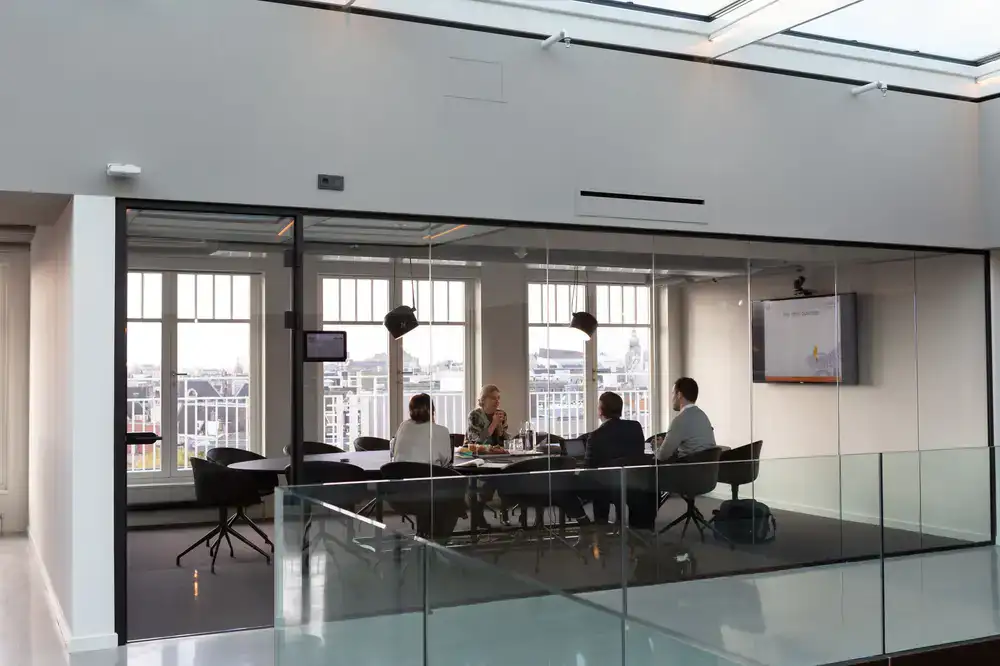 Employees collaborating in a plant-filled meeting area